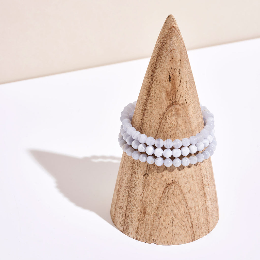 Photo de bracelets de pierre de Calcédoine Bleue autour d'un portant en bois