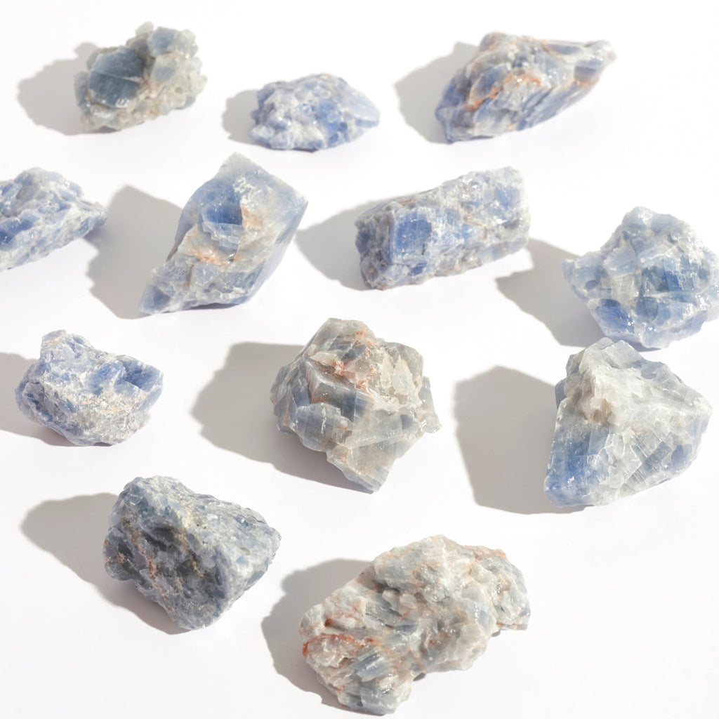 Photo de plusieurs pierre de Calcites Bleues brutes de la marque Let's Play On The Moon sur fond blanc 