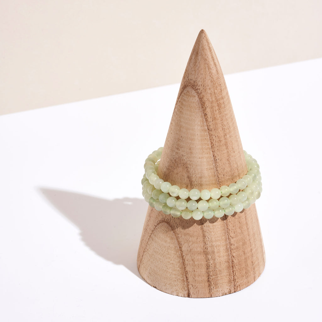 Photo de plusieurs bracelets en pierre de Jade sur un portant en bois