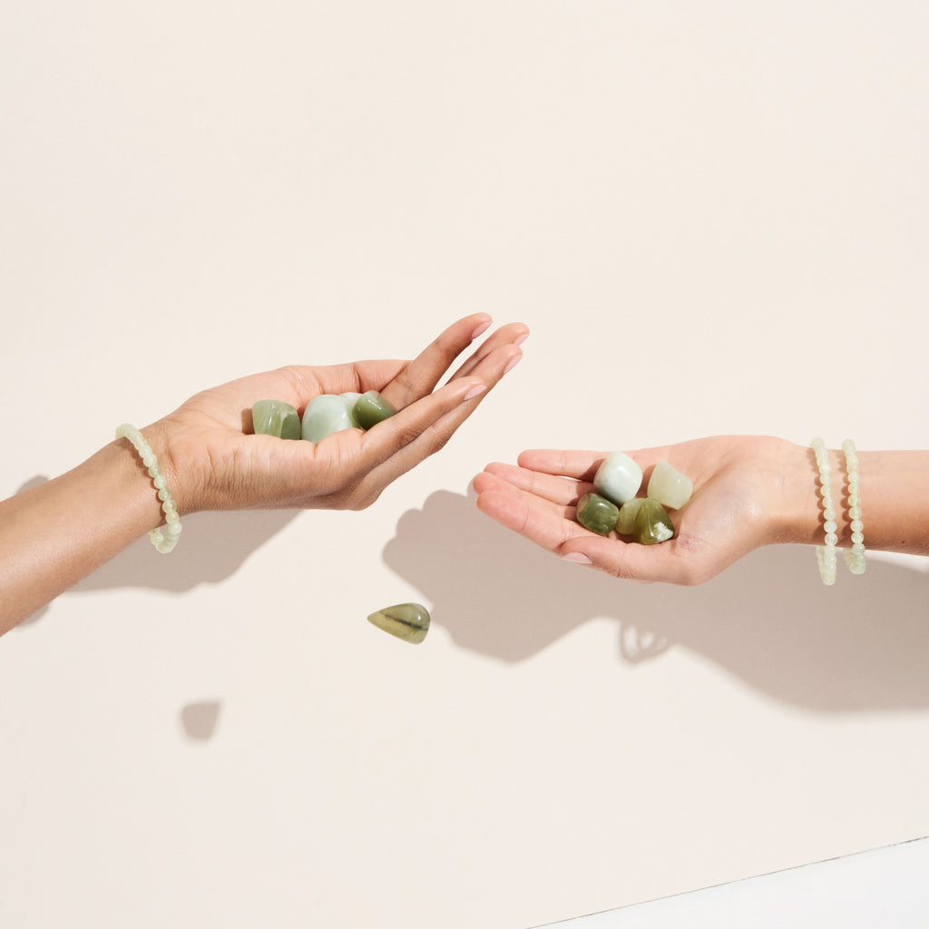 Photo de plusieurs pierres et bracelets de Jade tenus par des mains