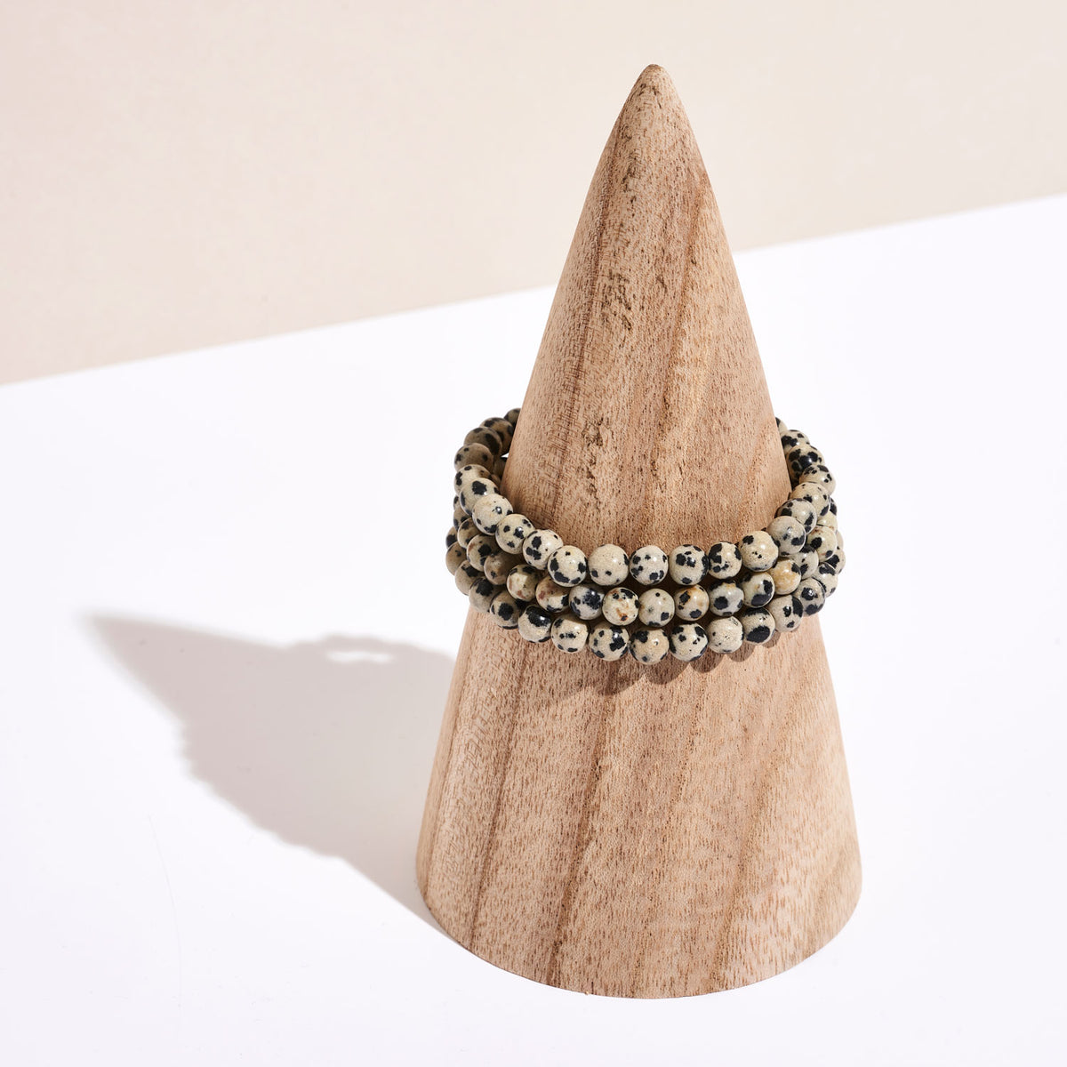 Photo de bracelet en pierre de Jaspe Dalmatien sur un portant en bois