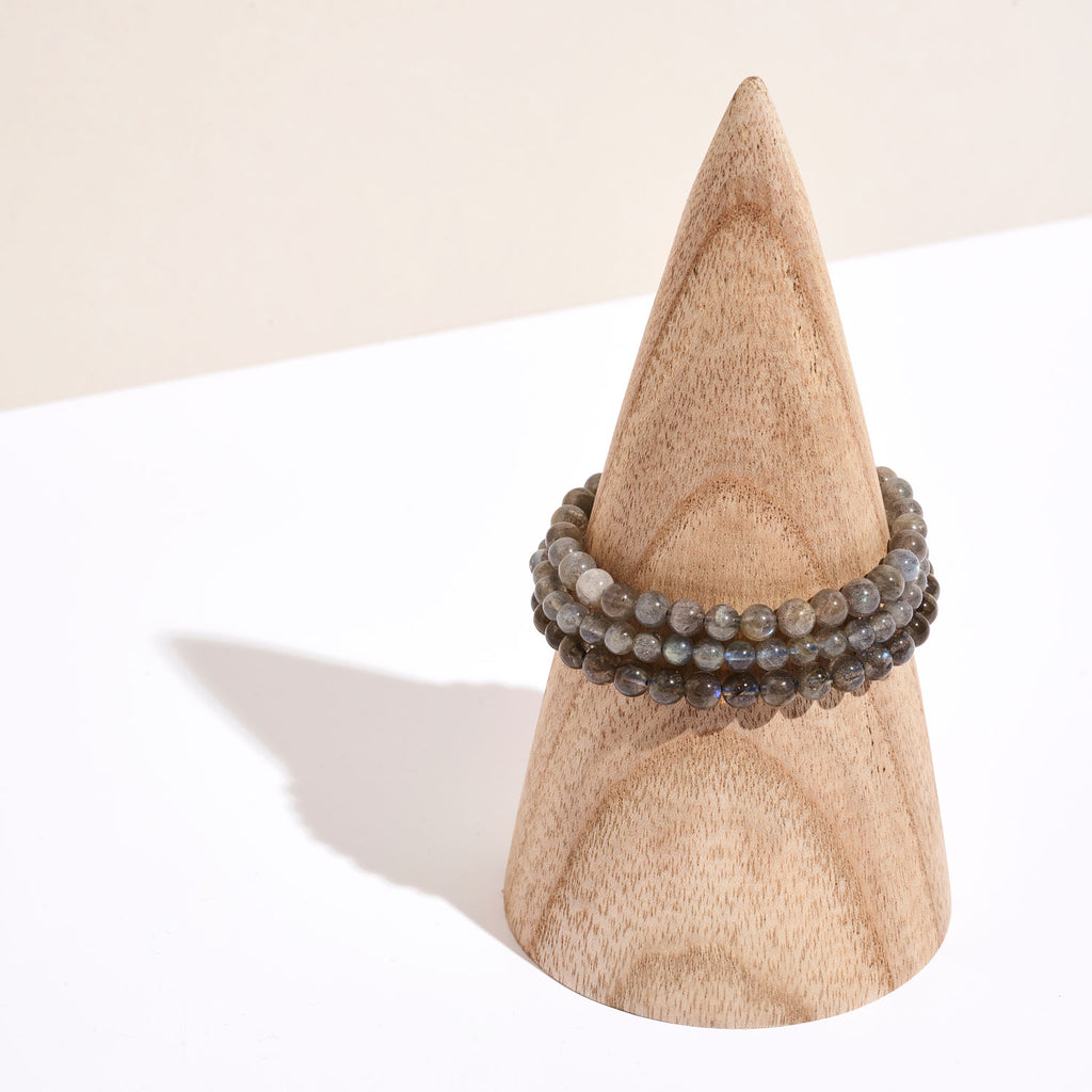 Photo de plusieurs bracelets de pierre de Labradorite  sur un portant en bois