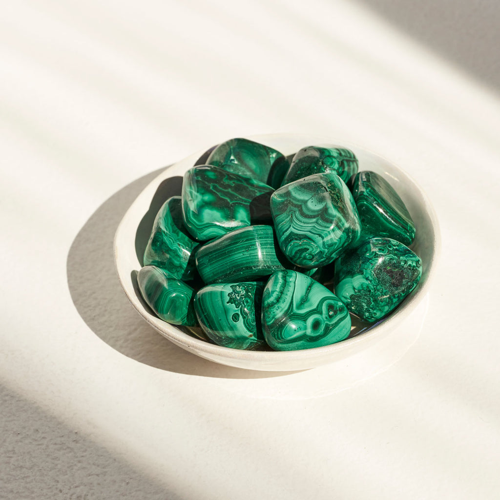 Photo de pierres de Malachite de couleur verte disposées dans une coupelle