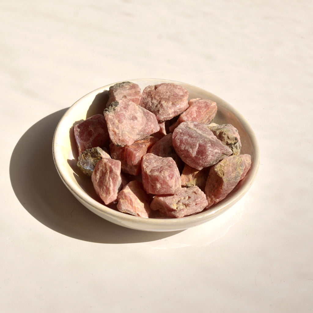 Photo de pierres de Rhodochrosite brute disposées dans une coupelle